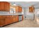 Functional kitchen with wood cabinets, stainless steel dishwasher, and neutral vinyl flooring at 5551 W 200 N, Greenfield, IN 46140