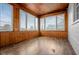Brightly lit sunroom with wood paneled walls, a view, and wood flooring at 5551 W 200 N, Greenfield, IN 46140