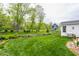 Expansive backyard featuring lush green lawn, mature trees, charming fence, and beautiful landscaping at 5682 Upper Garden Way, Zionsville, IN 46077