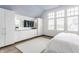 Bedroom with built-in dresser and wardrobes next to large windows for natural light at 5682 Upper Garden Way, Zionsville, IN 46077