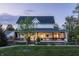 A charming two-story house featuring a covered porch, manicured lawn, and beautiful landscaping at 5682 Upper Garden Way, Zionsville, IN 46077