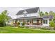 A two-story house with a covered front porch, wood railing, fenced yard, and lovely landscaped front yard at 5682 Upper Garden Way, Zionsville, IN 46077