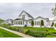 Beautiful white farmhouse featuring a sunroom, landscaped yard, and a quaint picket fence at 5682 Upper Garden Way, Zionsville, IN 46077