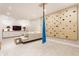 Basement living area with a climbing wall, comfortable seating, and entertainment center at 5682 Upper Garden Way, Zionsville, IN 46077