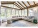 Bright sunroom featuring wood beams, multiple windows, and a comfortable seating area, perfect for relaxation at 5682 Upper Garden Way, Zionsville, IN 46077