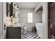 Stylish bathroom with a marble-top vanity, standalone tub, checkered floors, and wainscoting at 5946 N New Jersey St, Indianapolis, IN 46220