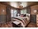 Cozy bedroom with a plush bed, patterned wallpaper, wood floors, and two windows with natural light at 5946 N New Jersey St, Indianapolis, IN 46220