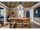 Dining room features a long wooden table, with patterned wallpaper, and a modern lighting fixture above the table at 5946 N New Jersey St, Indianapolis, IN 46220
