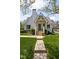 Quaint white brick home with landscaped yard and charming covered front porch with steps at 5946 N New Jersey St, Indianapolis, IN 46220