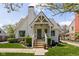Charming white brick home with a gable roof, landscaped yard, and inviting covered front porch at 5946 N New Jersey St, Indianapolis, IN 46220