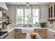 Bright kitchen featuring marble counters, wood floors, an apron front sink and a large window with natural light at 5946 N New Jersey St, Indianapolis, IN 46220
