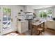 Well-lit kitchen featuring marble counters, wood floors, an apron front sink, and a door to the exterior at 5946 N New Jersey St, Indianapolis, IN 46220