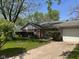 Ranch style home with a well-manicured lawn, attached garage, and mature trees under a sunny sky at 6040 Ipswich Ct, Indianapolis, IN 46254
