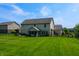 Well-maintained backyard with lush green grass, a screened patio and mature trees, ideal for outdoor activities at 6054 Easy Ln, Indianapolis, IN 46259