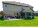 Spacious backyard featuring a brick patio, outdoor seating, a lush lawn, and a screened-in porch at 6054 Easy Ln, Indianapolis, IN 46259