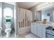 Bright bathroom featuring a shower-tub combo, white vanity, and an octagon-shaped window with natural light at 6054 Easy Ln, Indianapolis, IN 46259