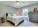 Cozy bedroom features neutral colors, ceiling fan, natural lighting, and dark wood furniture at 6054 Easy Ln, Indianapolis, IN 46259