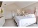 Spacious bedroom with a wooden headboard, plush carpeting, and a private bathroom entrance at 6054 Easy Ln, Indianapolis, IN 46259