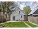 Charming backyard featuring a patio with sliding glass doors, green grass, and string lights at 611 Tecumseh St, Indianapolis, IN 46201