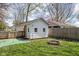 A backyard outbuilding with well-maintained grass, a fire pit, and mature trees at 611 Tecumseh St, Indianapolis, IN 46201