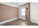 Bedroom features hardwood floors, neutral décor, and a decorative brick chimney at 611 Tecumseh St, Indianapolis, IN 46201