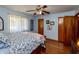 Bedroom features a ceiling fan, hardwood floors, and a cozy bed with plenty of natural light at 614 Debra Ln, Indianapolis, IN 46217