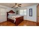 Bedroom features a ceiling fan, hardwood floors, and a cozy bed with plenty of natural light at 614 Debra Ln, Indianapolis, IN 46217