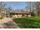 Charming single-story home with a stone facade, mature trees, and a well-maintained lawn at 614 Debra Ln, Indianapolis, IN 46217