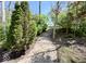 Landscaped backyard with brick walkway leading to concrete steps through the trees at 6157 Winthrop Ave, Indianapolis, IN 46220