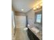 Well-lit bathroom featuring granite countertops, tile flooring, shower-tub combo, and modern fixtures at 6157 Winthrop Ave, Indianapolis, IN 46220