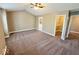 Expansive main bedroom features a vaulted ceiling, soft carpet, and ensuite bathroom access at 6157 Winthrop Ave, Indianapolis, IN 46220