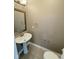 Stylish powder room featuring a pedestal sink, decorative mirror, and neutral decor at 6157 Winthrop Ave, Indianapolis, IN 46220