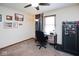 Bedroom with ceiling fan, desk and chair, with neutral colored walls, and a large gun safe at 6232 Buck Trail Rd, Indianapolis, IN 46237