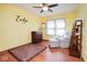 Bright bedroom with hardwood floors, light-yellow walls, and ceiling fan at 6232 Buck Trail Rd, Indianapolis, IN 46237
