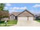 Well-maintained brick home with a driveway, two-car garage, and landscaped front yard at 6232 Buck Trail Rd, Indianapolis, IN 46237