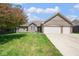 Charming brick home with a two-car garage, manicured lawn, and blossoming foliage at 6232 Buck Trail Rd, Indianapolis, IN 46237