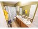 Bathroom featuring a dual sink vanity, large mirror, and shower with blue butterfly-themed curtain at 6376 Matcumbe Way, Plainfield, IN 46168