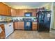 Functional kitchen equipped with stainless steel appliances, wooden cabinetry, and easy-to-clean tile floors at 6376 Matcumbe Way, Plainfield, IN 46168