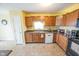 Traditional kitchen with brown cabinets, black countertops, and stainless steel appliances at 6376 Matcumbe Way, Plainfield, IN 46168