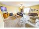 Cozy living room featuring neutral walls, plush carpeting, ceiling fan, and ample natural light at 6376 Matcumbe Way, Plainfield, IN 46168