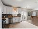 Spacious kitchen features white cabinetry, tiled backsplash, stainless appliances, bar seating, and access to a patio at 6514 Trevia Ct, Indianapolis, IN 46236
