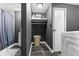 Functional laundry and storage area with shelving, a laundry basket, and a washing machine at 6514 Trevia Ct, Indianapolis, IN 46236