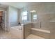 Spa-like bathroom features a walk-in shower with a built-in seat and a soaking tub at 7144 Hart St, Cumberland, IN 46229