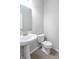 Bathroom features a pedestal sink, white toilet, and wood-look flooring at 7144 Hart St, Cumberland, IN 46229