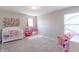 bedroom with carpet floors, crib, princess vanity, toys, and window at 7144 Hart St, Cumberland, IN 46229