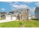 Inviting home with a three-car garage, nicely landscaped front yard, and classic architectural details at 7144 Hart St, Cumberland, IN 46229