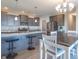 Modern kitchen features a granite island with bar seating, stainless appliances, and gray cabinetry at 7144 Hart St, Cumberland, IN 46229