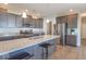 Well-appointed kitchen features a granite island with seating, modern appliances, and gray cabinetry at 7144 Hart St, Cumberland, IN 46229