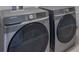 Modern laundry room featuring a gray front load washer and dryer at 7144 Hart St, Cumberland, IN 46229