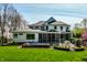 View of backyard with hot tub, screen porch, patio with firepit, outdoor furniture, and manicured landscaping at 7602 N Pennsylvania St, Indianapolis, IN 46240